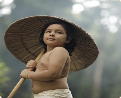 Child holding a traditional palm-leaf umbrella